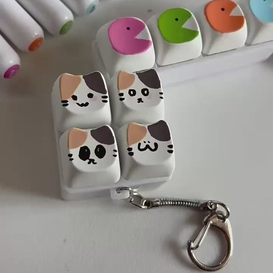 Mechanical click button keychain with tactile keyboard-style switches for stress relief and focus, compact fidget toy attached to a keyring.