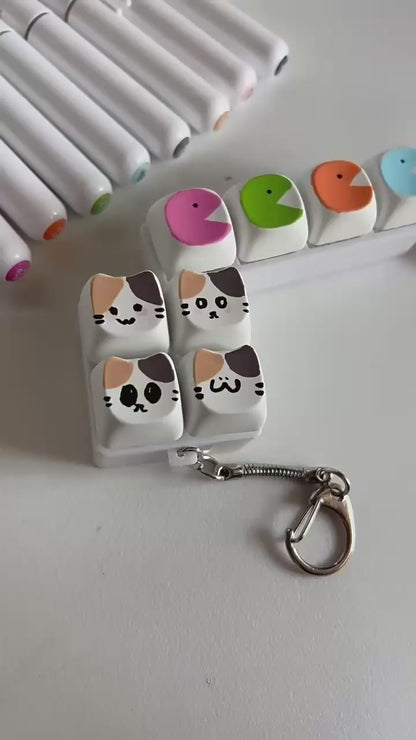 Mechanical click button keychain with tactile keyboard-style switches for stress relief and focus, compact fidget toy attached to a keyring.